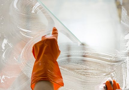 nahaufnahme-hand-mit-gummihandschuh-reinigungsfenster